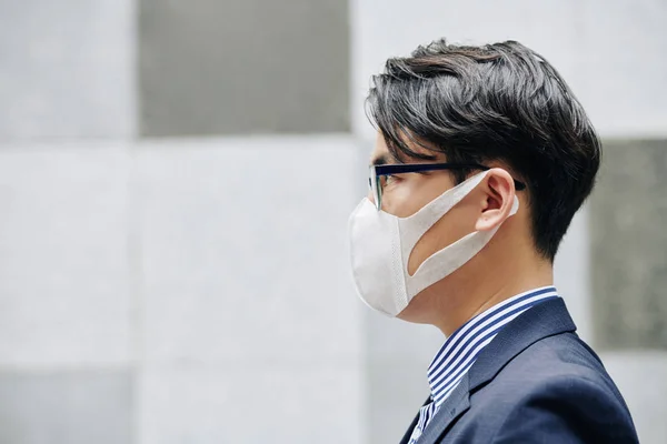 香港因空气污染而戴防护面具的严重亚裔男子的侧影 — 图库照片