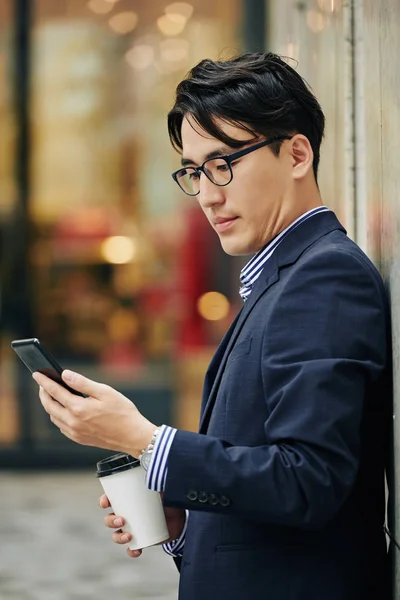Podnikatel Brýlích Pití Ranní Kávy Kontrolu Novinek Prostřednictvím Aplikace Smartphone — Stock fotografie