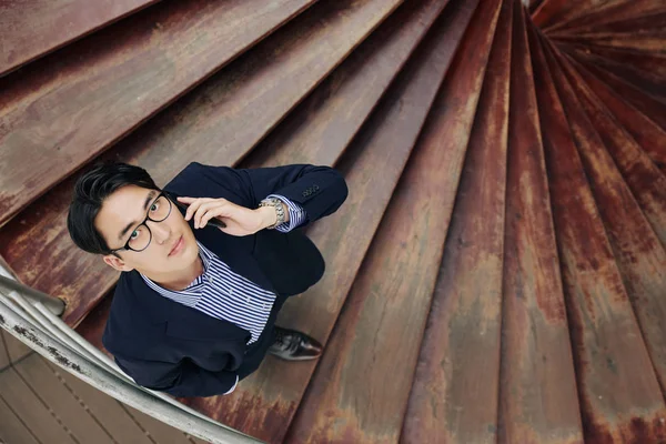 Genç Asyalı Girişimci Ahşap Merdivenlerden Iniyor Telefonla Konuşuyor Kameraya Bakıyor — Stok fotoğraf