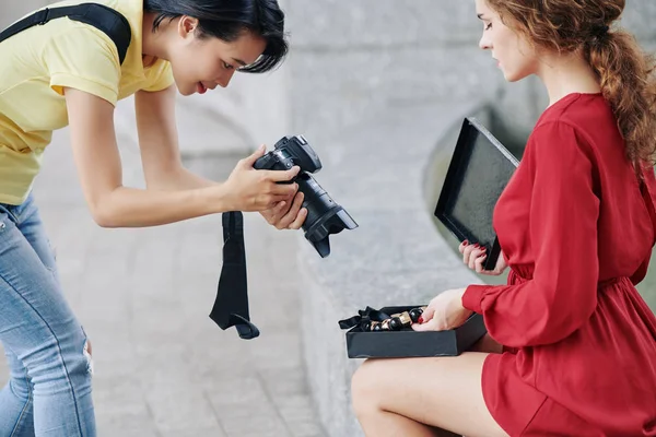 Junge Frau Rotem Kleid Öffnet Geschenkbox Und Zeigt Dem Fotografen — Stockfoto