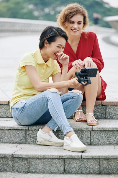 Pretty Young Multi Ethnic Women Sitting Steps Outdoors Watching Video — 스톡 사진