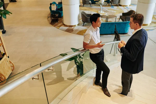 Seriöse Multiethnische Geschäftsleute Stehen Auf Treppen Schicken Bürogebäuden Und Sprechen — Stockfoto