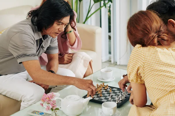 Orta Yaşlı Bir Çift Yetişkin Çocuklarıyla Satranç Oynuyor Çay Içiyor — Stok fotoğraf