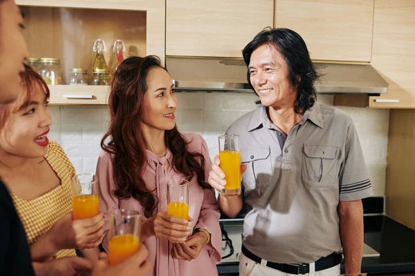 Asiatisk Familj Tittar Leende Far Skålar Med Glas Apelsinjuice — Stockfoto