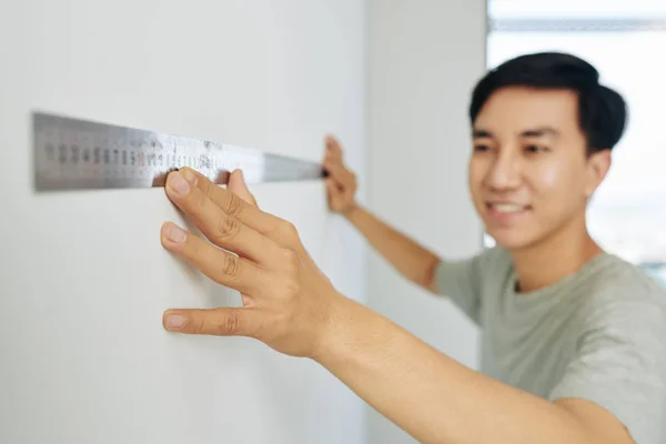 Jovem Sorridente Usando Régua Metal Medir Parede Seu Apartamento — Fotografia de Stock