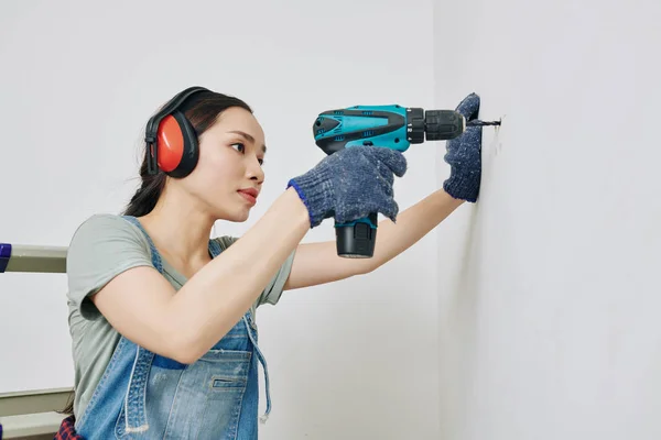 Jolie Jeune Femme Vietnamienne Concentrée Sur Mur Forage Dans Chambre — Photo
