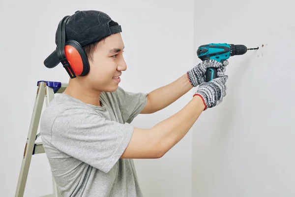 Smiling Young Vietnamese Man Wearing Protective Ear Muffs Gloves Drilling — 스톡 사진