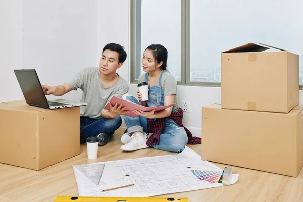 Junges Vietnamesisches Paar Sitzt Seiner Neuen Wohnung Mit Bauplan Auf — Stockfoto