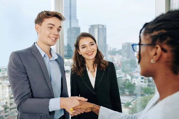 Fröhliche Junge Geschäftsleute Begrüßen Neue Mitarbeiterin Büro Und Schütteln Ihr — Stockfoto