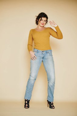 Hardallı, uzun kollu, yalnız dans eden mutlu bir genç kadın.