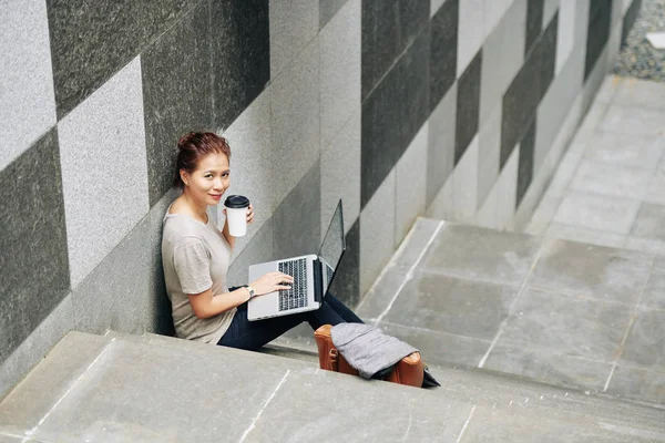 Pozitivní Mladá Vietnamka Sedí Schodech Šálkem Kávy Notebooku Když Dělá — Stock fotografie