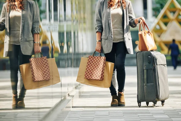 大都市で週末を過ごした後に大きなスーツケースと多くのショッピングバッグを持つ女性の作物のイメージ — ストック写真