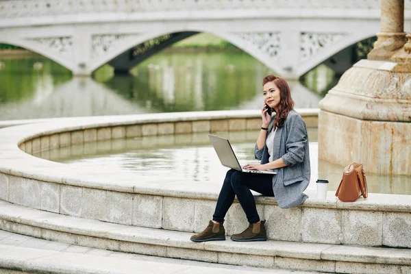 Freelance Pretty Smiling Woman Sitting Fountain Working Laptop Calling Phone — Stock Photo, Image