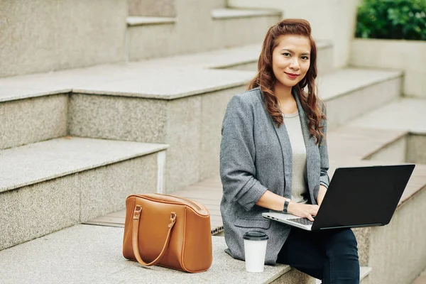 Retrato Empresária Vietnamita Positiva Sentada Livre Bebendo Café Digitando Laptop — Fotografia de Stock