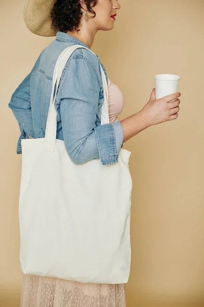 新鮮な水の紙ガラスを飲むリネン再利用可能な袋を持つスタイリッシュな若い女性の作物のイメージ — ストック写真