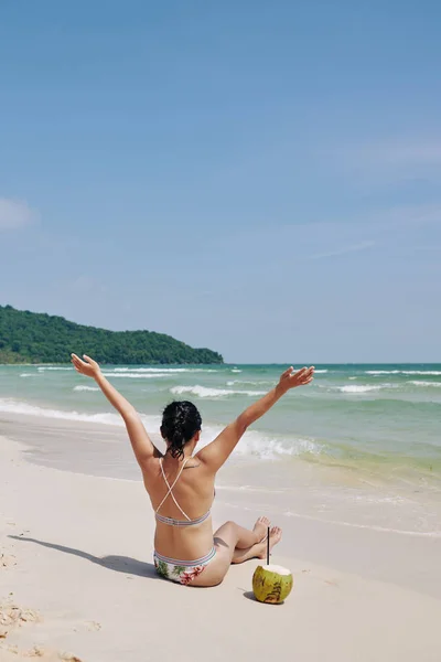 Giovane Donna Bikini Seduta Sulla Spiaggia Deserta Che Beve Acqua — Foto Stock