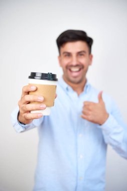 Mutlu iş adamı sabah kahvesini gösteriyor.