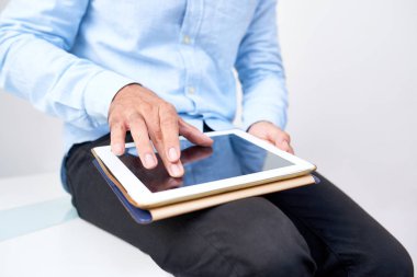 İş adamı internette biraz bilgi arıyor ve tablet bilgisayarının ekranındaki resimlere zumluyor