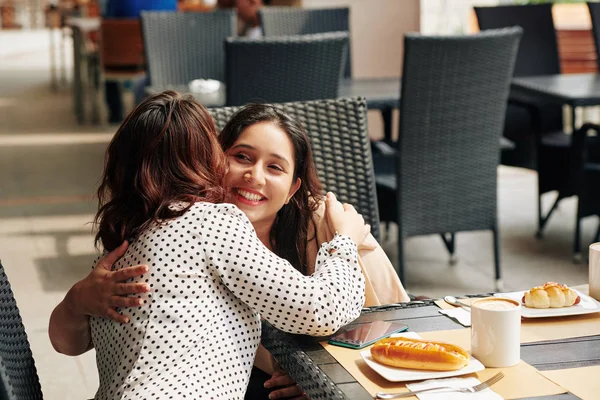 快乐漂亮的年轻女子拥抱着她在户外咖啡馆遇见的朋友 — 图库照片
