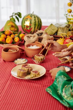 Ay Yeni Yılı kutlamalarında geleneksel abur cubur ve yemekler yiyen insanların elleri