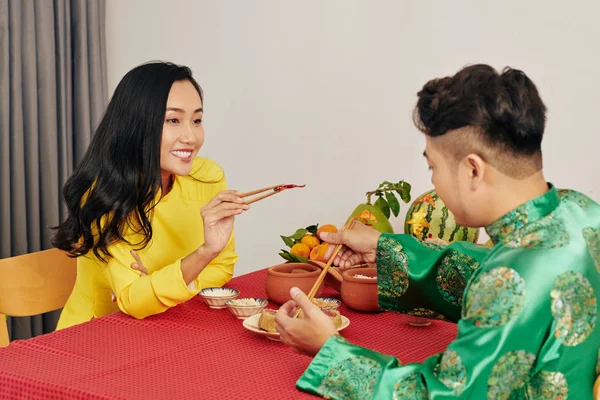 浪漫的年轻夫妇在家里庆祝农历新年时吃着美味的食物 — 图库照片