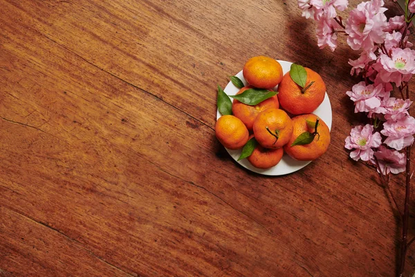 Branche Pêcher Fleurs Assiette Avec Mandarines Fraîches Mûres Sur Table — Photo
