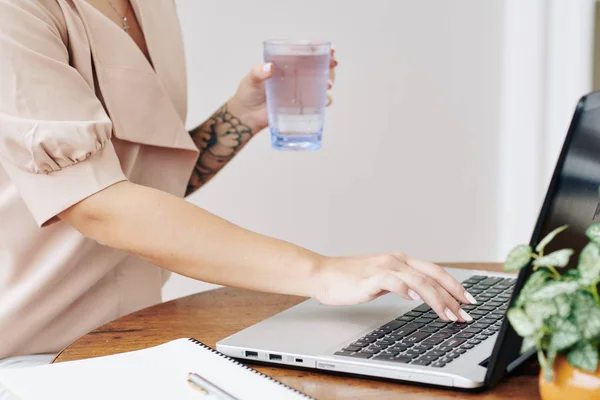 Обрізане Зображення Молодої Жінки Склянкою Прісної Води Працює Ноутбуці Перевіряє — стокове фото