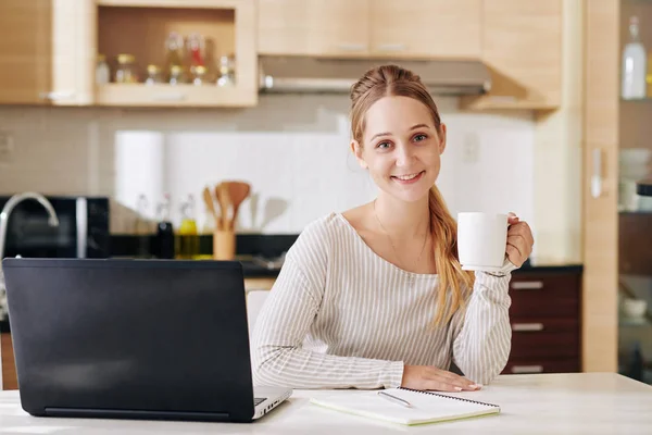 Mooie Glimlachende Jonge Vrouw Zitten Aan Keukentafel Met Kopje Koffie — Stockfoto