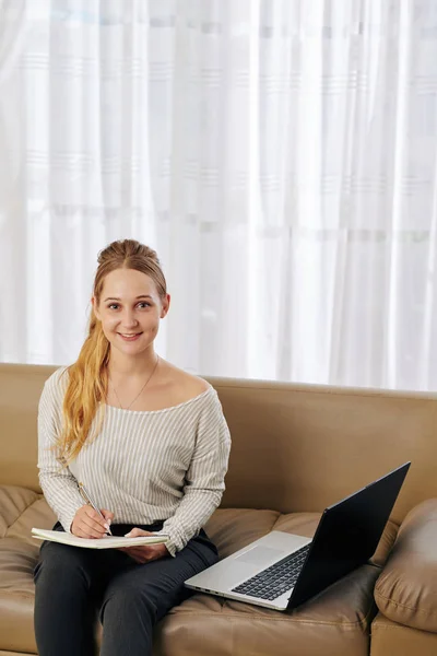 Estudante Muito Sorridente Sentada Sofá Com Laptop Aberto Escrevendo Livro — Fotografia de Stock