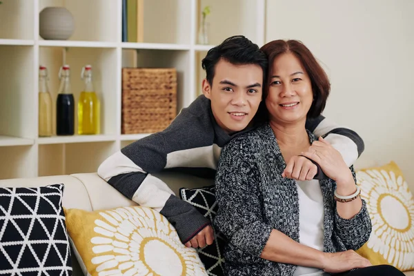 Sorridente Giovane Asiatico Uomo Abbracciando Sua Madre Mezza Età Seduta — Foto Stock