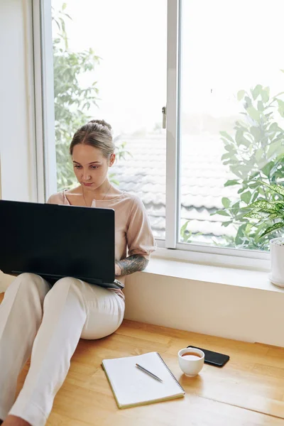 Kvinna Bär Casual Outfit Arbetar Laptop Hemma Sitter Mot Fönstret — Stockfoto