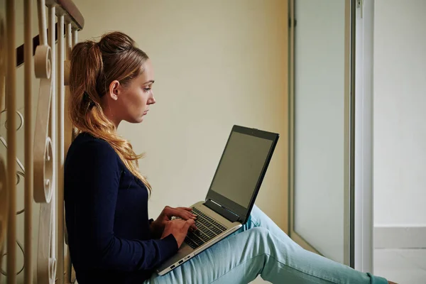 Piękna Młoda Kobieta Stylową Fryzurę Siedzi Podłodze Pomocą Laptopa Poziomego — Zdjęcie stockowe