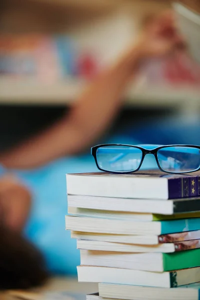 Vertikale Aufnahme Einer Brille Auf Einem Bücherstapel Mit Unkenntlich Gemachten — Stockfoto