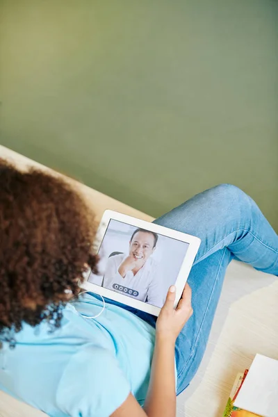 女孩坐在沙发上 用数码平板电脑与成熟的男人交谈 — 图库照片