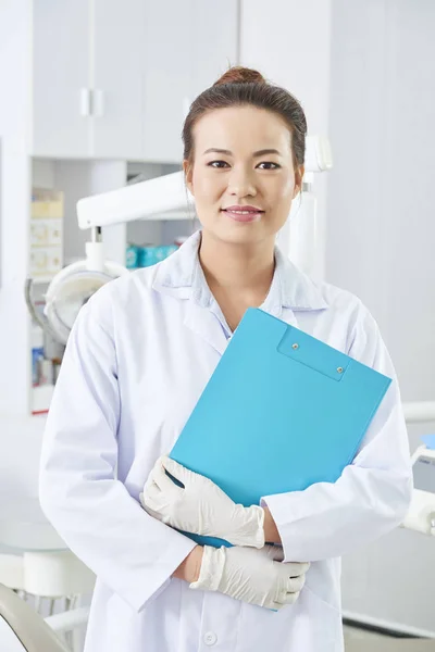 Vertical Médio Retrato Bela Asiática Dentista Feminina Segurando Prancheta Azul — Fotografia de Stock