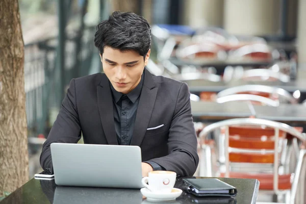 Retrato Horizontal Joven Ocupado Usando Traje Sentado Cafetería Trabajando Netbook —  Fotos de Stock