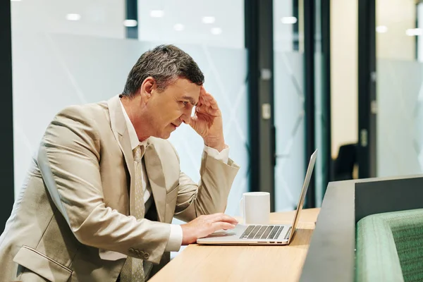 Bej Takım Elbiseli Yorgun Bir Adamın Ofis Masasında Dizüstü Bilgisayarla — Stok fotoğraf