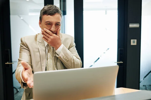 ノートパソコンの画面を見て手で彼の口をカバーする失敗のためにストレスアウト中年のビジネスマン感じ — ストック写真