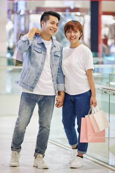 时尚的亚洲夫妇站在现代购物中心 提着手提包向远方望去 照片的垂直全景 — 图库照片