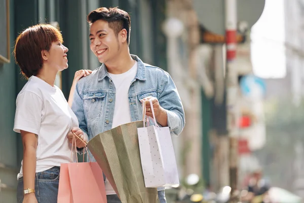 带着购物袋的快乐的亚洲男人和女人在户外享受购物的水平中景 — 图库照片