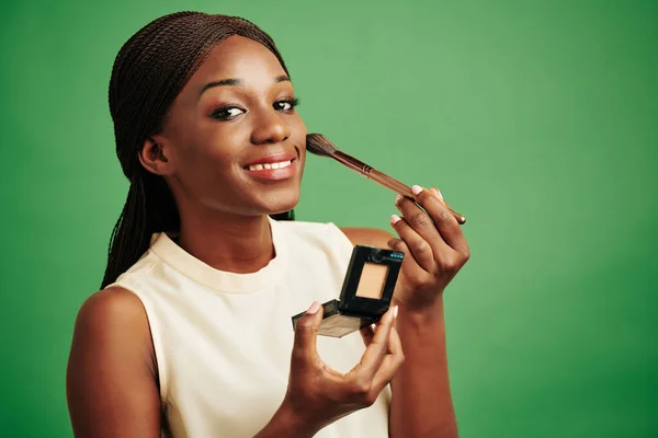 Mulher Afro Americana Aplicando Maquiagem Seu Rosto Olhando Para Câmera — Fotografia de Stock
