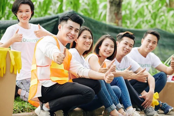 Glückliche Junge Asiatische Studenten Sitzen Freiwillig Draußen Lächeln Und Zeigen — Stockfoto