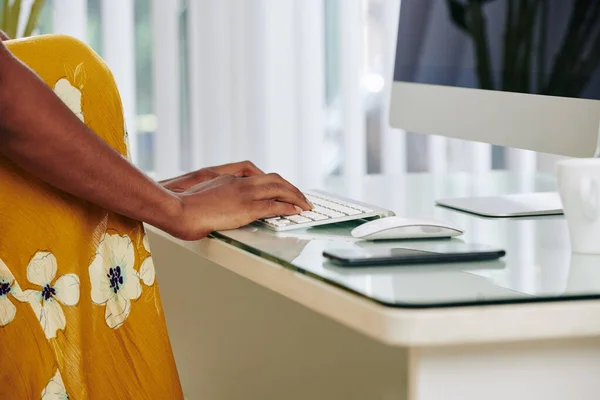 Cropped image of woman sending e-mails to her coworkers, relatives and friends