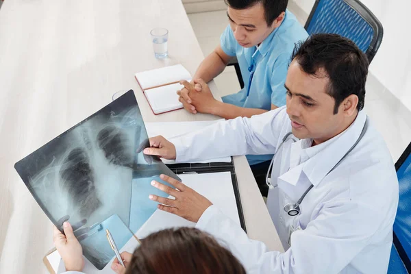 肺科医生与他的小组讨论病人的肺X光检查 并寻找结肠癌的征象 — 图库照片