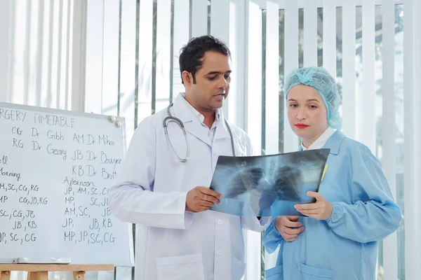 의사와 과장은 코로나 바이러스에 것으로 의심되는 환자의 엑스레이에 논의한다 — 스톡 사진