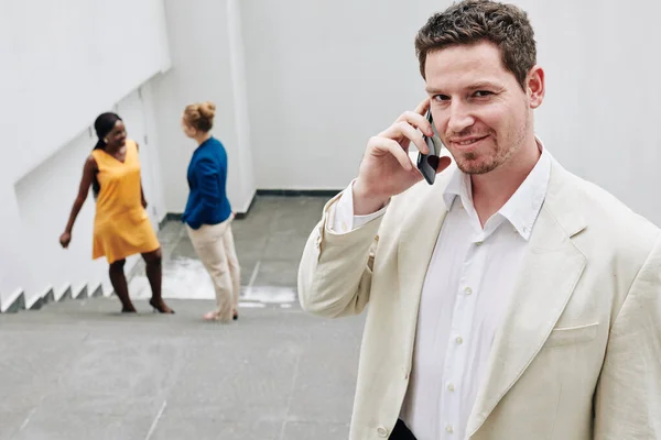 Portrét Pohledného Mladého Usměvavého Podnikatele Mluvícího Telefonu Dívajícího Kamery — Stock fotografie