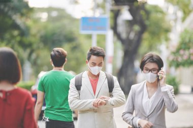 Tıbbi maskeli Asyalılar, yoldan geçen virüs ve hastalıklara karşı korunuyorlar.