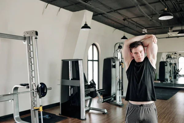 Fit Sterke Jongeman Stretching Armen Kijken Naar Camera Bij Het Stockafbeelding