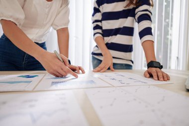 Kadın girişimcilerin mali verilerle grafikleri tartışırken, harcamaları hesaplarken ve iş planlarken kesilen görüntüleri