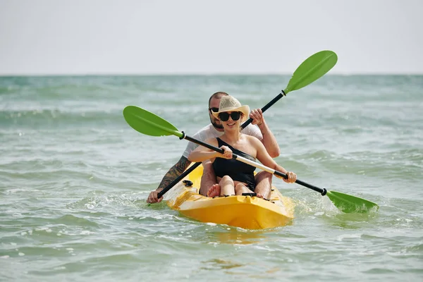 坐在海上皮划艇上戴太阳镜的快乐的年轻夫妇 — 图库照片